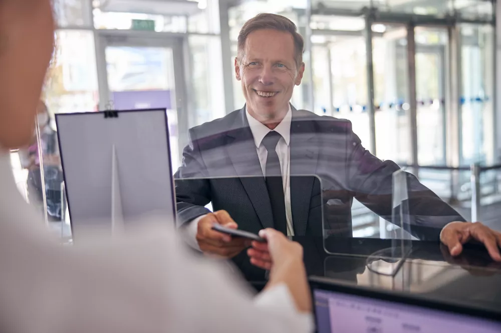 cheerful-mature-man-elegant-suit-is-giving-documents-checking-female-officer-desk