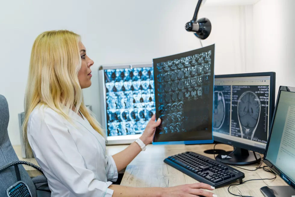 woman-radiologist-holding-x-ray-film-near-computer-office-background-modern-equipment