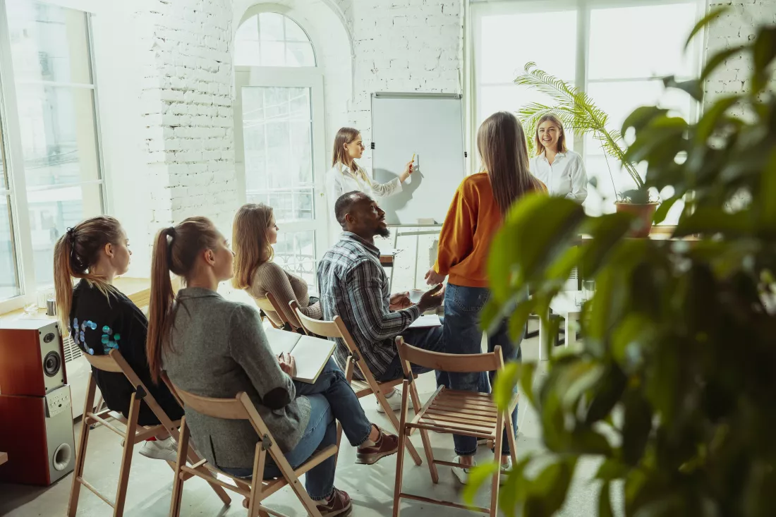 asking-question-female-speaker-giving-presentation-hall-workshop-business-centre-rear-view-participants-audience-conference-event-training-education-diversity-inclusive-concept