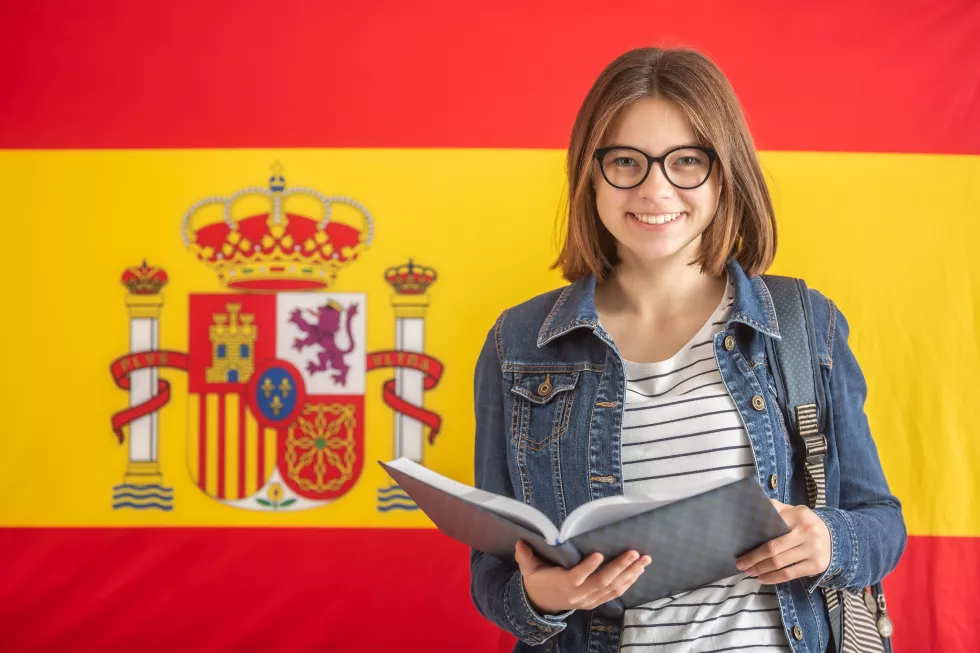 young-female-student-glasses-hold-open-textbook-front-flag-spain