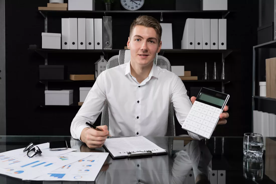 portrait-young-man-business-space-sitting-table-bright-office