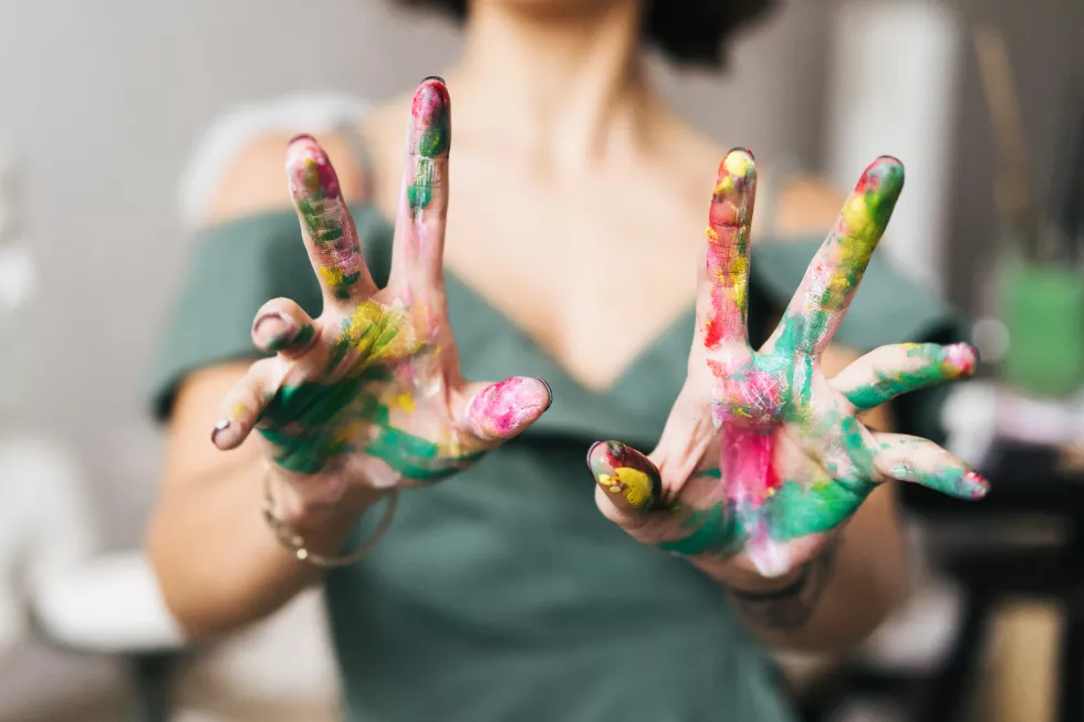 midsection-woman-with-messy-painted-hands-home
