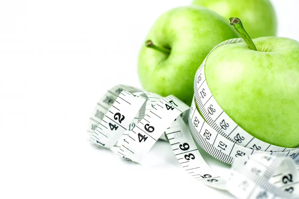 green-apple-with-measuring-tape-white-background