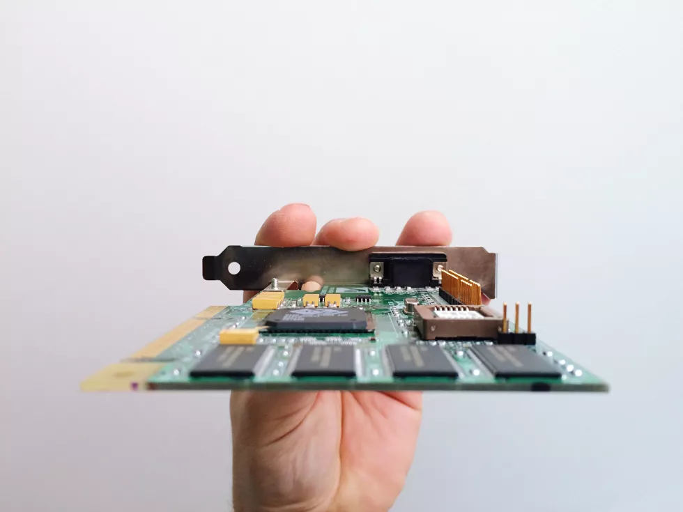 cropped-hand-holding-circuit-board-against-white-background