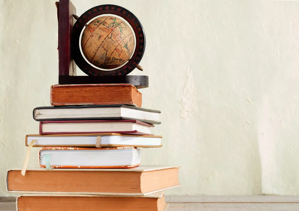 close-up-books-table-against-wall