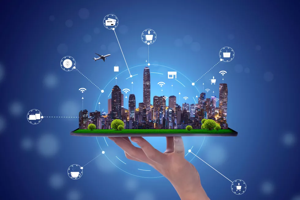 digital-composite-image-hand-holding-city-against-blue-sky