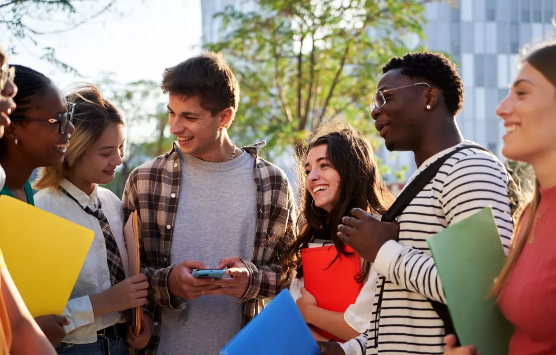 Studenci z roznych krajow rozmawiaja przed budynkiem uczelni