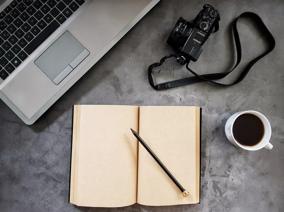 high-angle-view-laptop-table-notepad-desk-coffee-camera