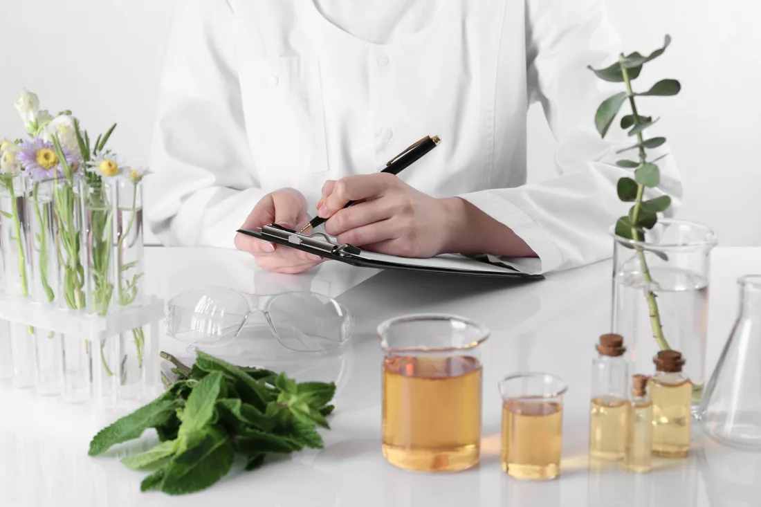 aromatherapy-product-scientist-developing-essential-oils-white-table-laboratory-closeup
