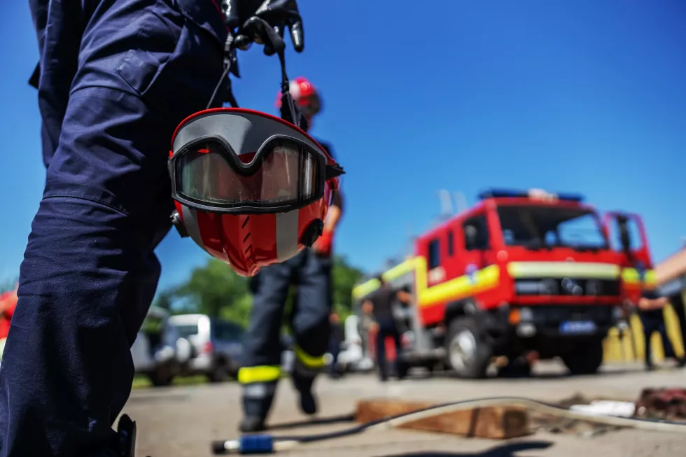 closeup-firefighter-holding-his-helmet-walking-towards-fire-truck