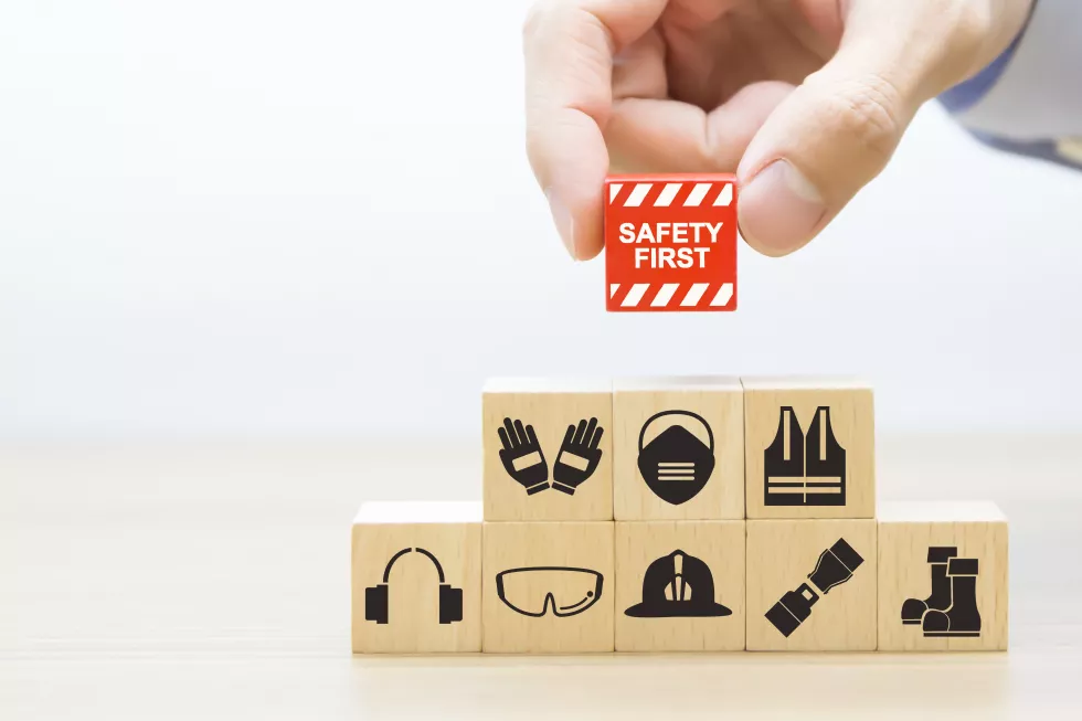 close-up-hand-choose-wooden-blocks-stacked-with-safety-first-icons