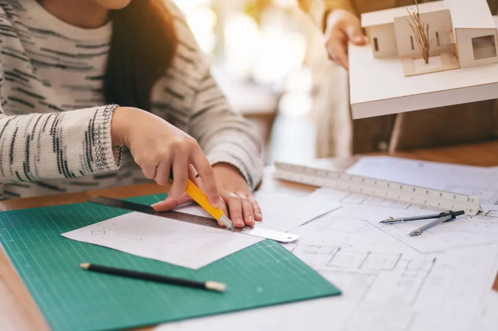 midsection-woman-holding-pencils-table