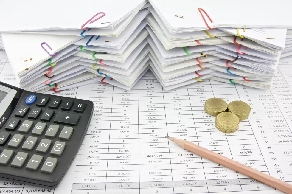 high-angle-view-papers-stacked-by-calculator-pencil-table