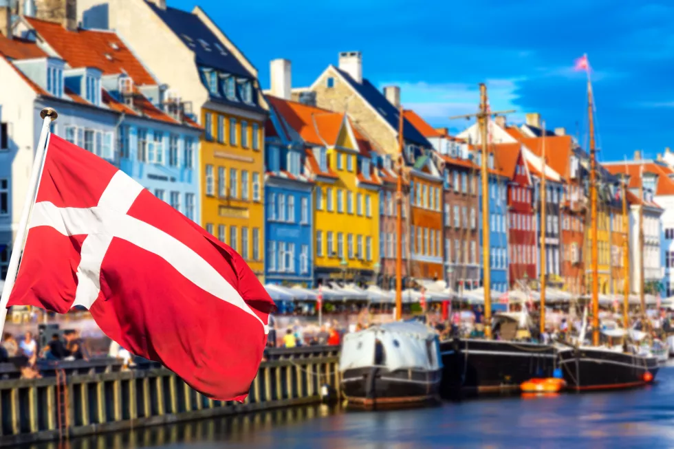 copenhagen-iconic-view-famous-old-nyhavn-port-center-copenhagen-denmark-summer-sunny-day-with-denmark-flag-foreground