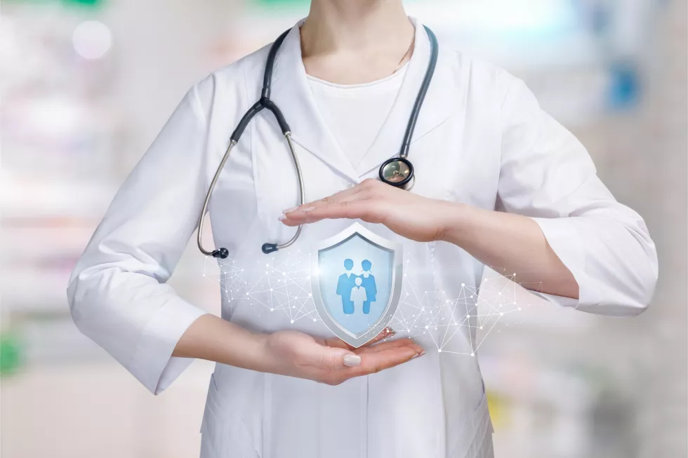young-doctor-is-holding-big-shield-with-group-people-family-members-icon-inside-her-palms-protective-gesture