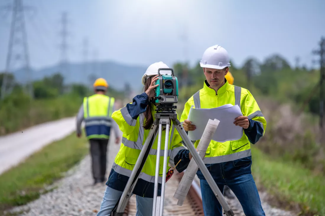 portrait-surveyors-wearing-uniform-conversation-notebook-blueprint-check-inspection-by-theodolite-camera-measurement-level-position-road-construction-site-is-industry-transportation-concept