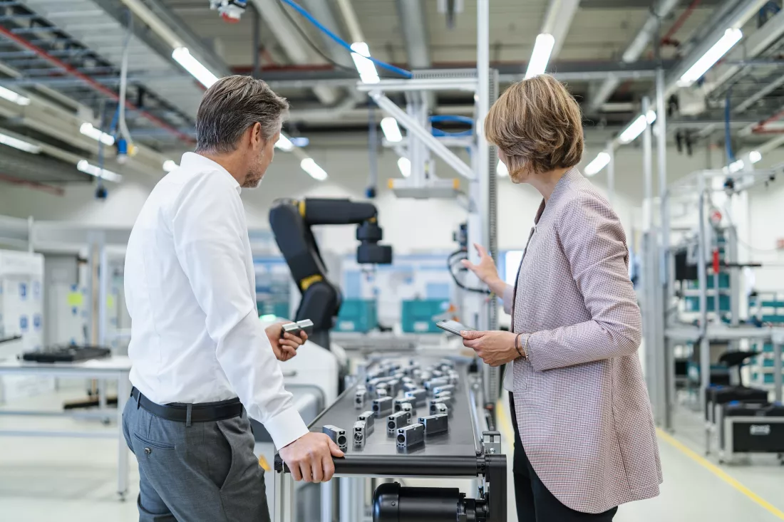 businessman-businesswoman-talking-modern-factory-hall