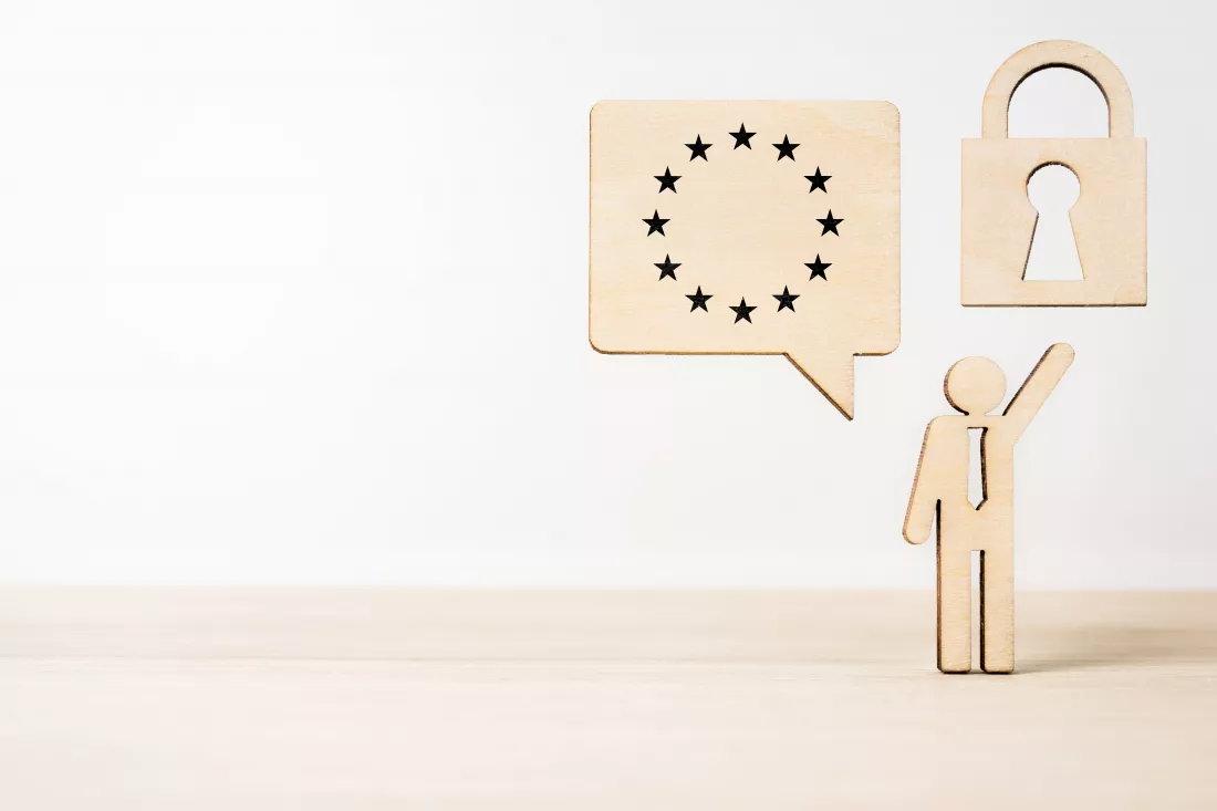 close-up-figurine-by-thought-bubble-padlock-table-against-wall