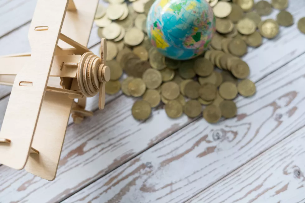 holiday-saving-plan-metaphor-wooden-airplane-bed-gold-coins