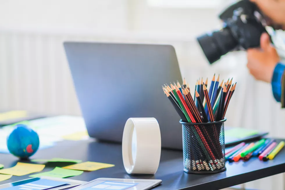 close-up-colored-pencils-with-laptop-papers-table
