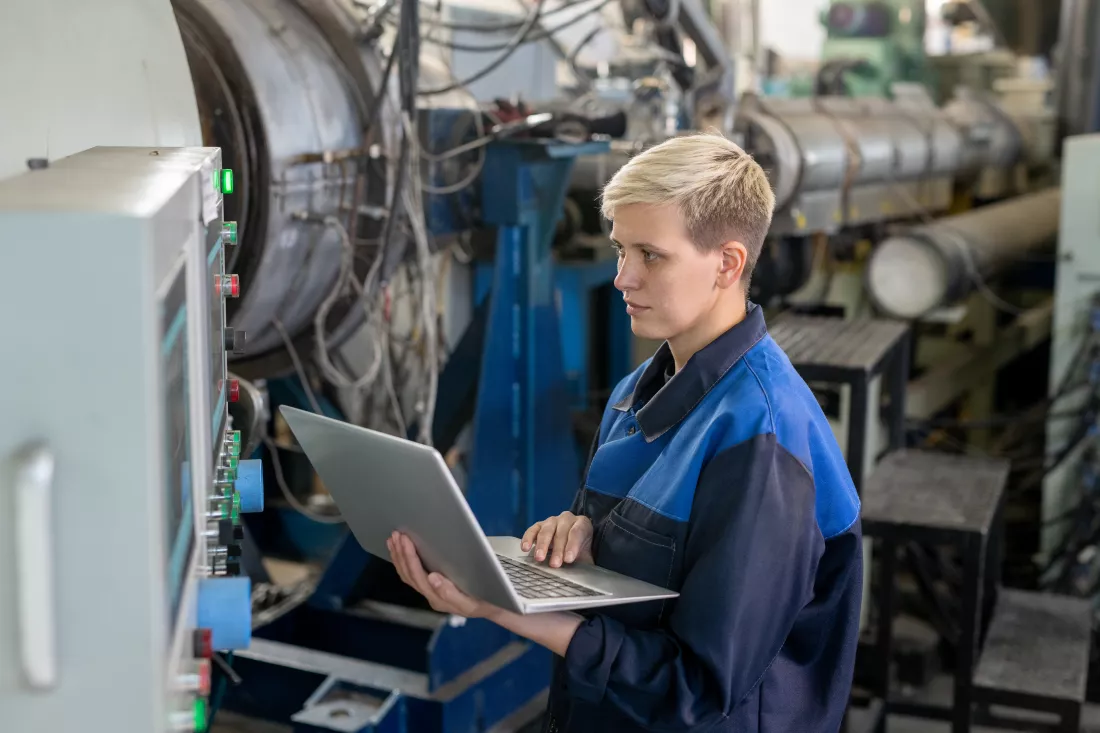 young-serious-blond-female-worker-overalls-using-laptop-while-looking-through-online-technical-data-against-industrial-equipment-workshop(2)